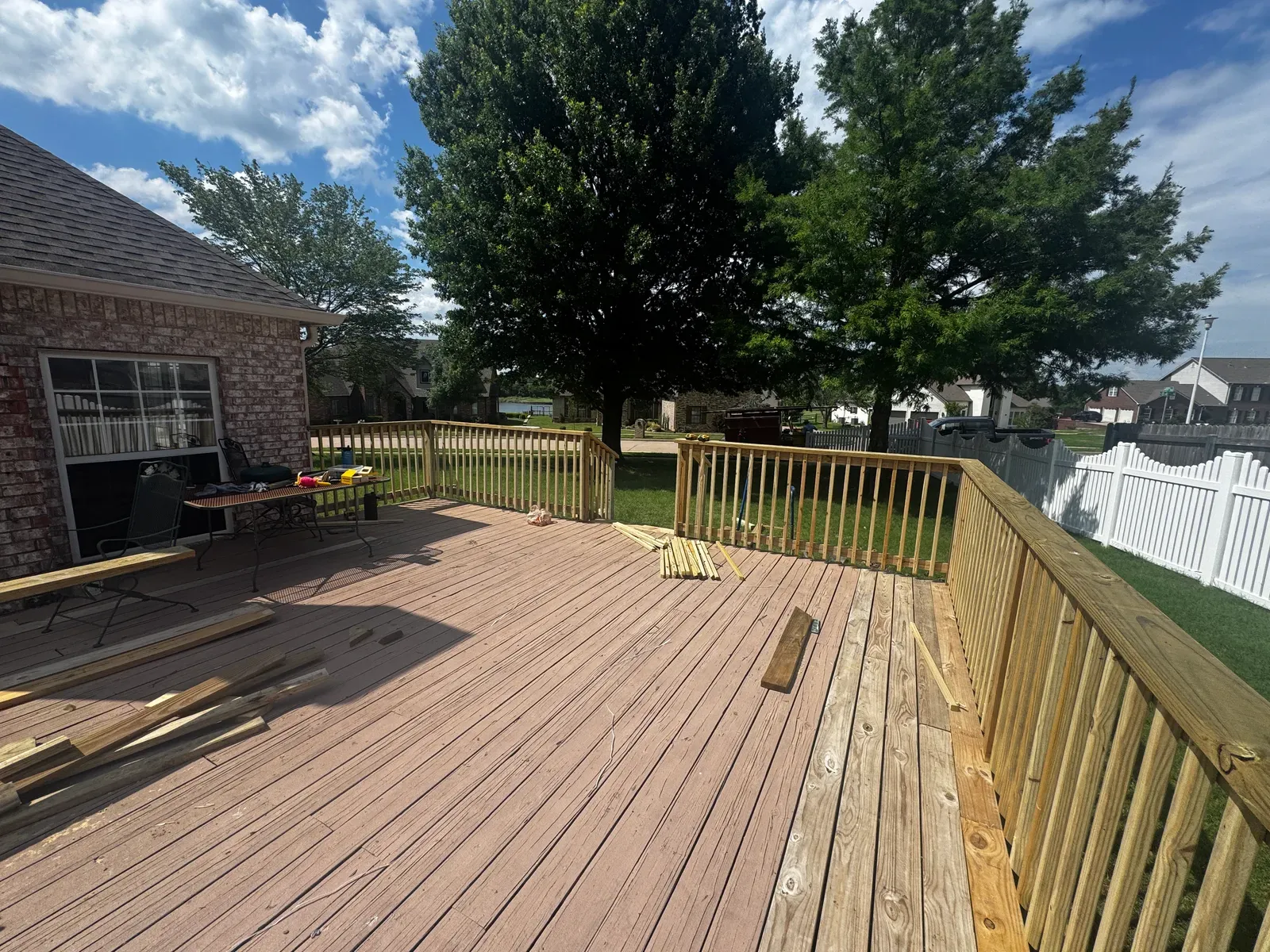 Deck rebuild in progress with new pressure-treated railing going up