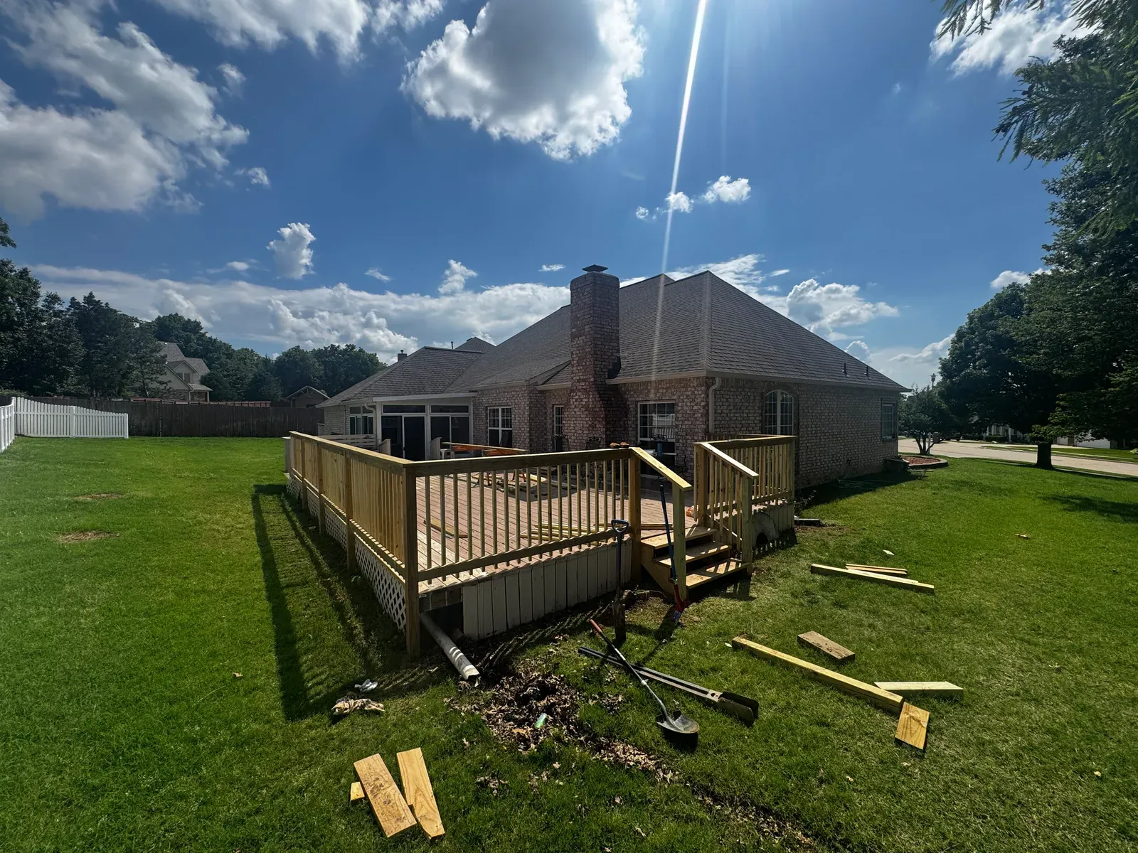 Backyard deck with new railing and steps during the rebuild