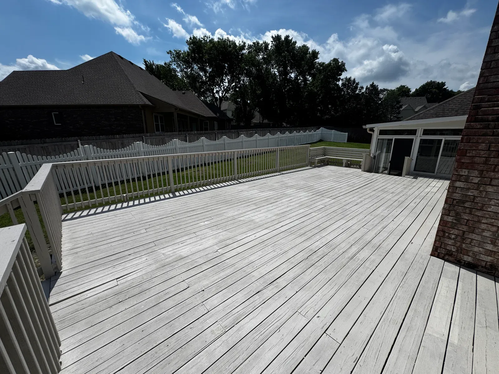 Finished deck with white railing behind an Oklahoma home