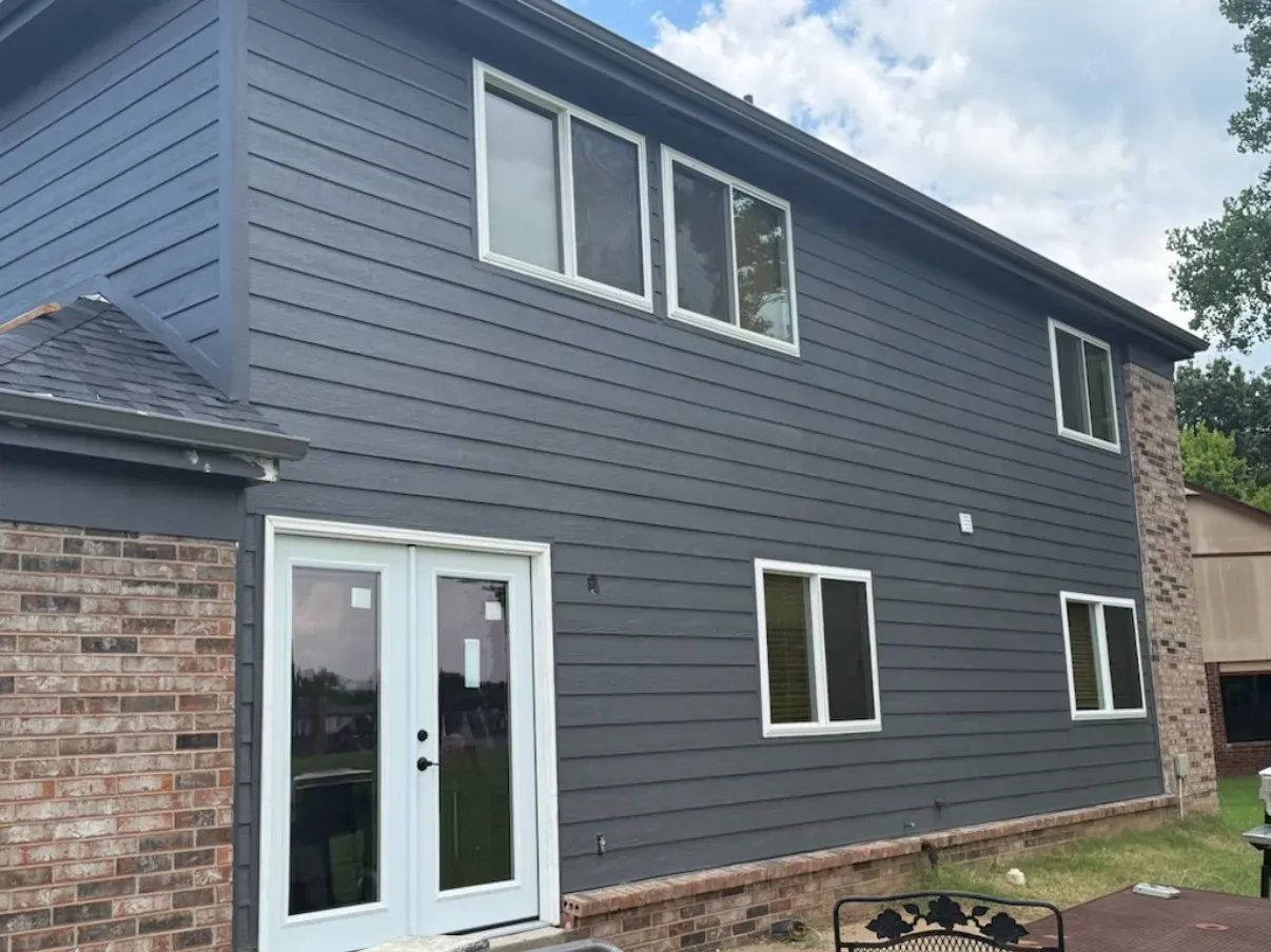 After: the same home with new gray lap siding, new windows, and French doors by Morgan Windows