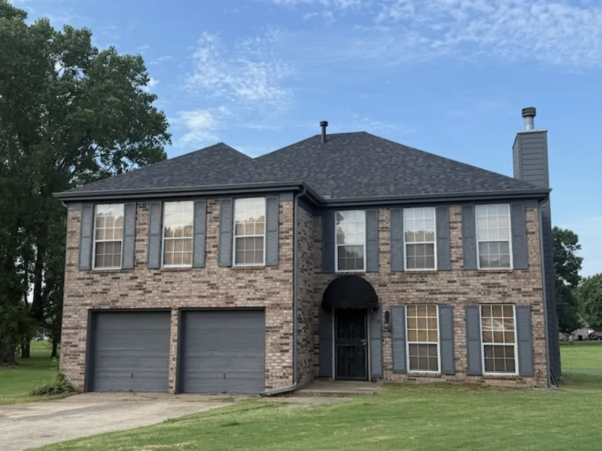 Two-story brick home with new white windows installed by Morgan Windows
